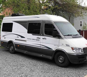A white van with "Vista Cruiser" branding parked on a gravel surface.