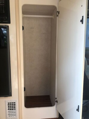 A vehicle interior with a white door, a small window, and a vent. - Cozy private camper with hookups, budget base for NYC, bus 2 blocks away (Linden)