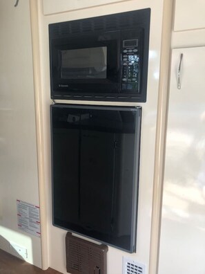 A kitchen with a microwave and a refrigerator. - Cozy RV, direct bus to NYC 2 blocks away, MetLife Stadium 30 minutes (Linden)