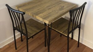 A small wooden table with four chairs, each with a curved backrest.