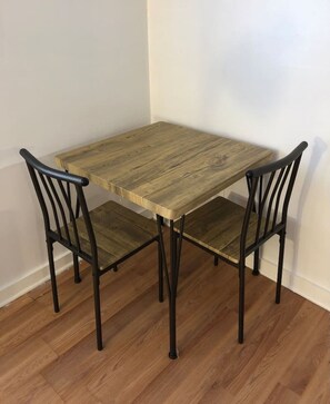 A small wooden table with four chairs, each with a curved backrest.