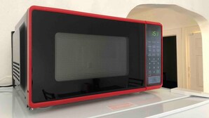 A microwave with a red frame and a digital display on the right side.
