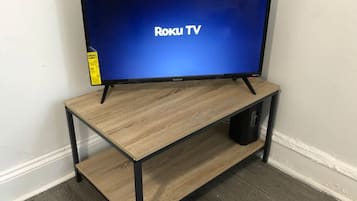Een televisie op een houten standaard, met een plank eronder.