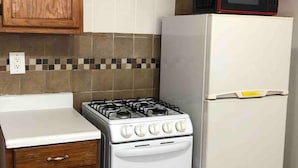 A kitchen with wooden cabinets, a white stove, and a white refrigerator.