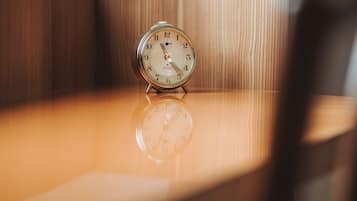Un reloj despertador antiguo sobre una superficie reflectante.