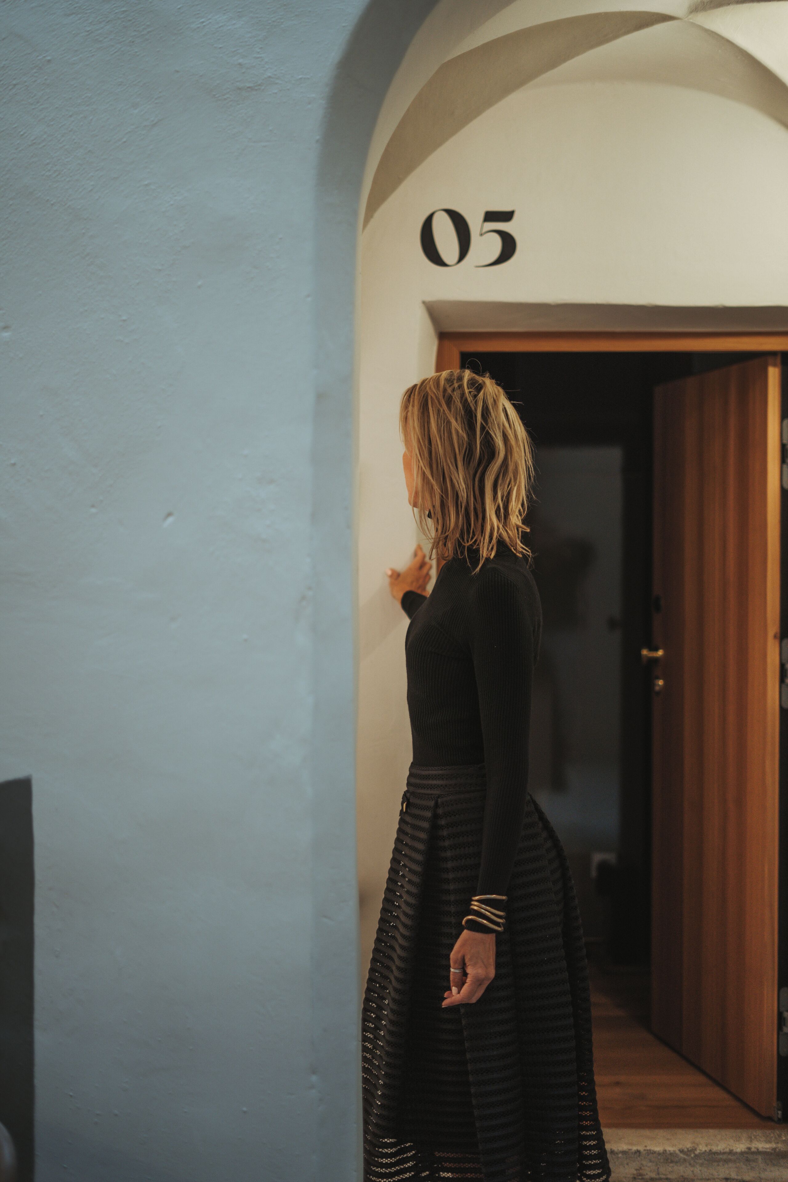 Une personne se tient dans un couloir, et le chiffre « 05 » est inscrit sur le mur.