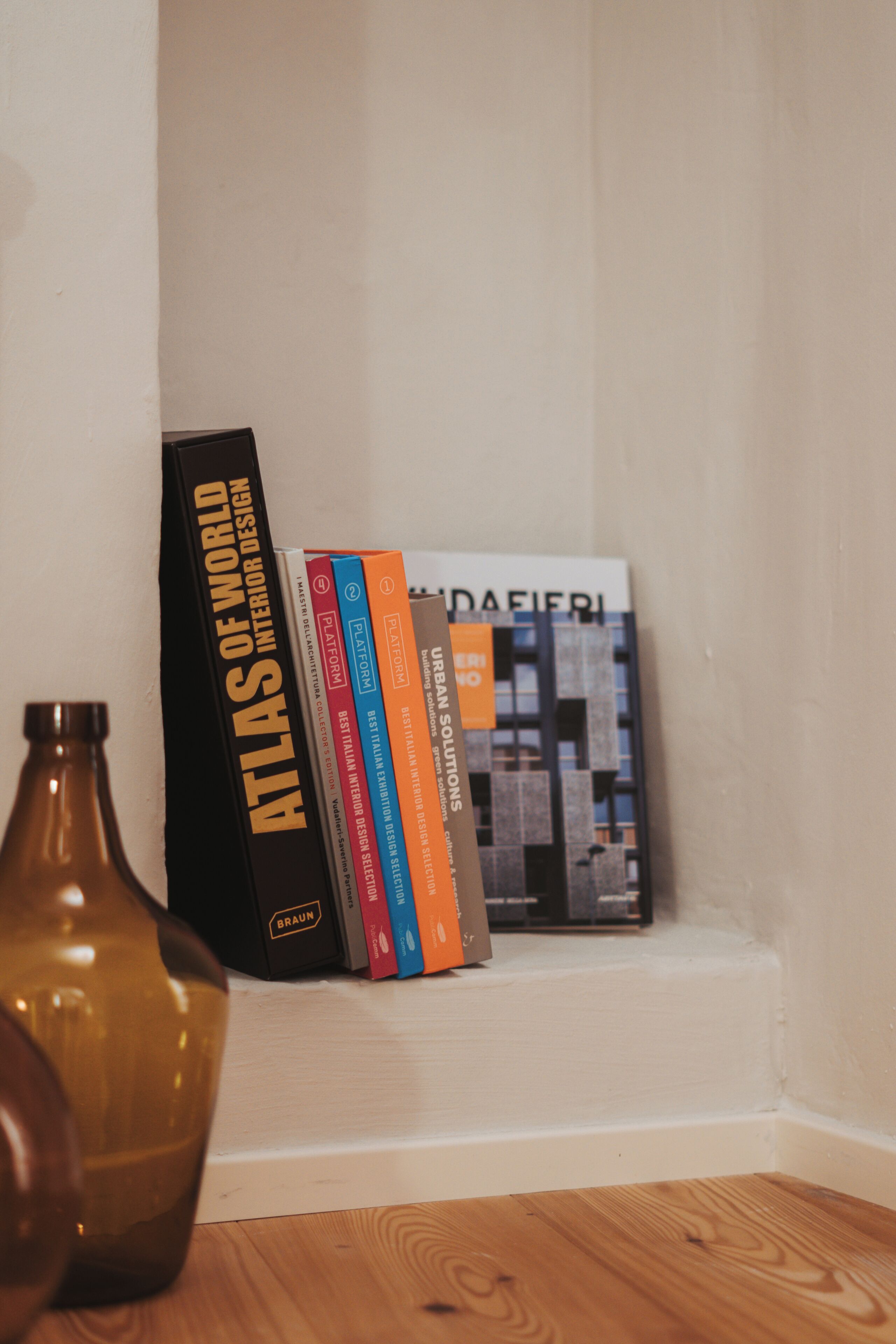Una libreria con libri e un vaso.