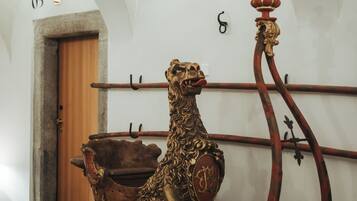 Une pièce dotée d’une porte en bois, d’une statue de lion décorative posée sur une luge et d’un plafond voûté.