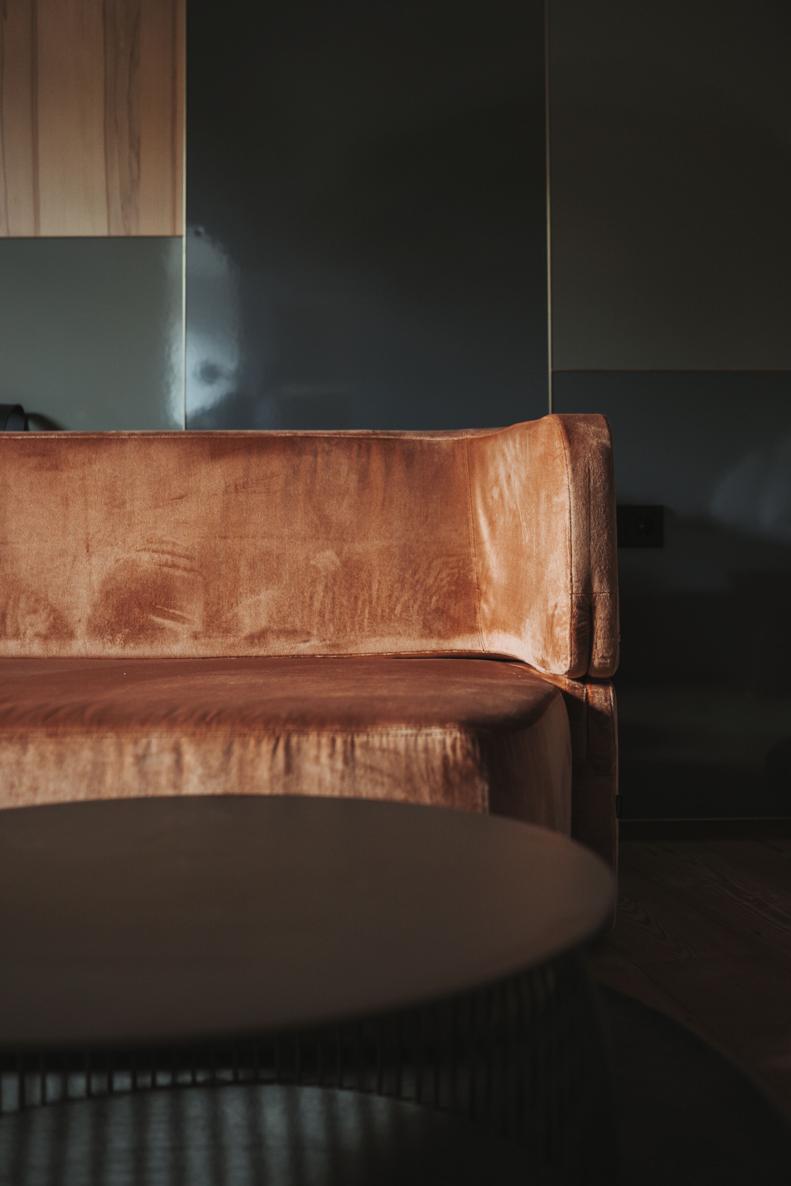 Una sala de estar moderna con un sofá de cuero marrón y una mesa de centro redonda.