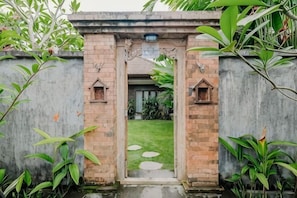 Une entrée en briques agrémentée d’un petit jardin et de quelques pas japonais.