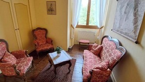 Una habitación con dos sillones, un sofá y una mesita con una planta.