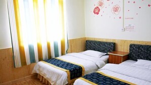A hotel room with two beds, wooden flooring, and a window with curtains. - Wenxin Homestay (Zhangjiajie)