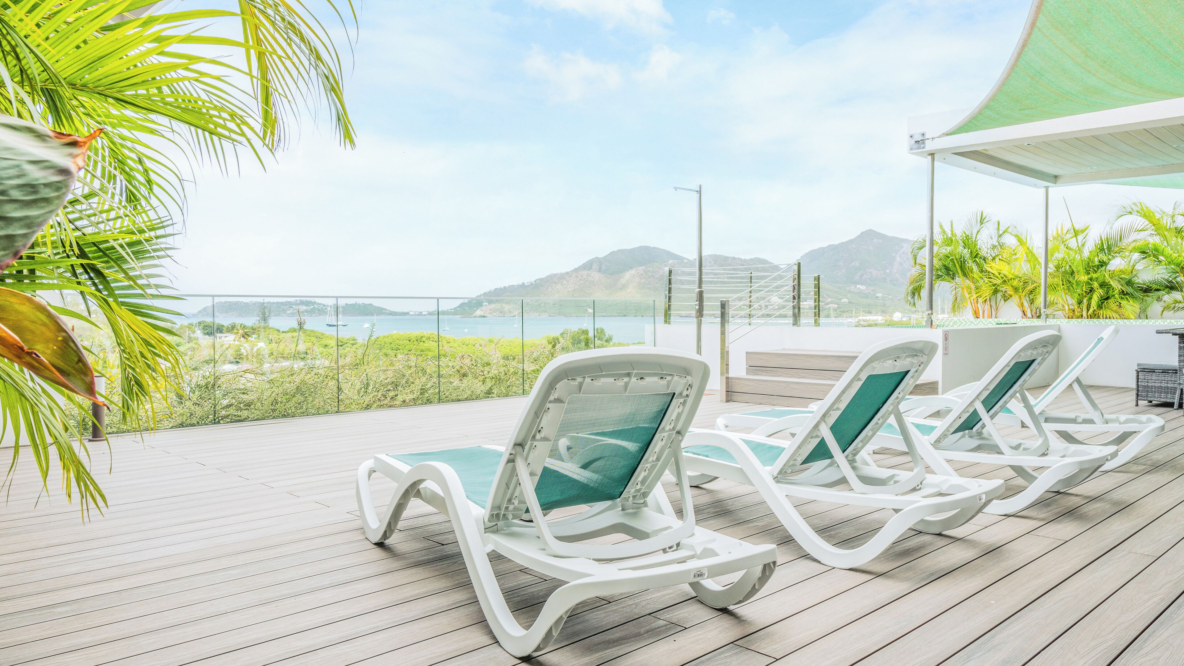 A deck with lounge chairs and a view of the sea.
