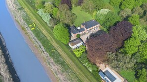 Luchtbeeld van een pand met een groot huis, een zwembad en een rivier.
