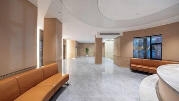 A spacious lobby with a curved ceiling, a reception desk, and seating areas.