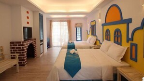 Habitación de hotel con dos camas, televisión, chimenea y ventana con cortinas.