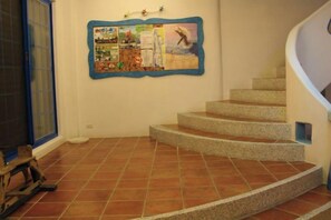 A spiral staircase with a bulletin board on the wall. - Meet Kenting Hostel (Pingtung)