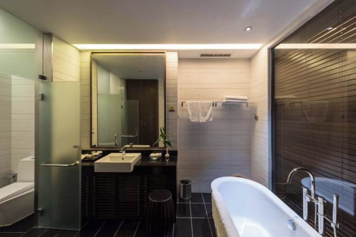 Un baño moderno con bañera, lavabo y espejo.