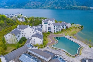 Un hôtel comprenant plusieurs bâtiments, une piscine et offrant une vue sur un lac.