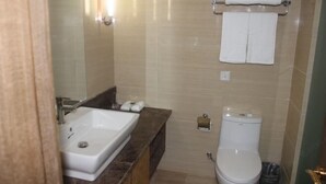 A bathroom with a sink, toilet, and towel rack.