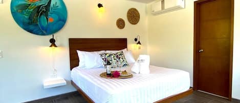 A bedroom with a wooden bed, a round wall decoration, two wall-mounted lamps, and a door.
