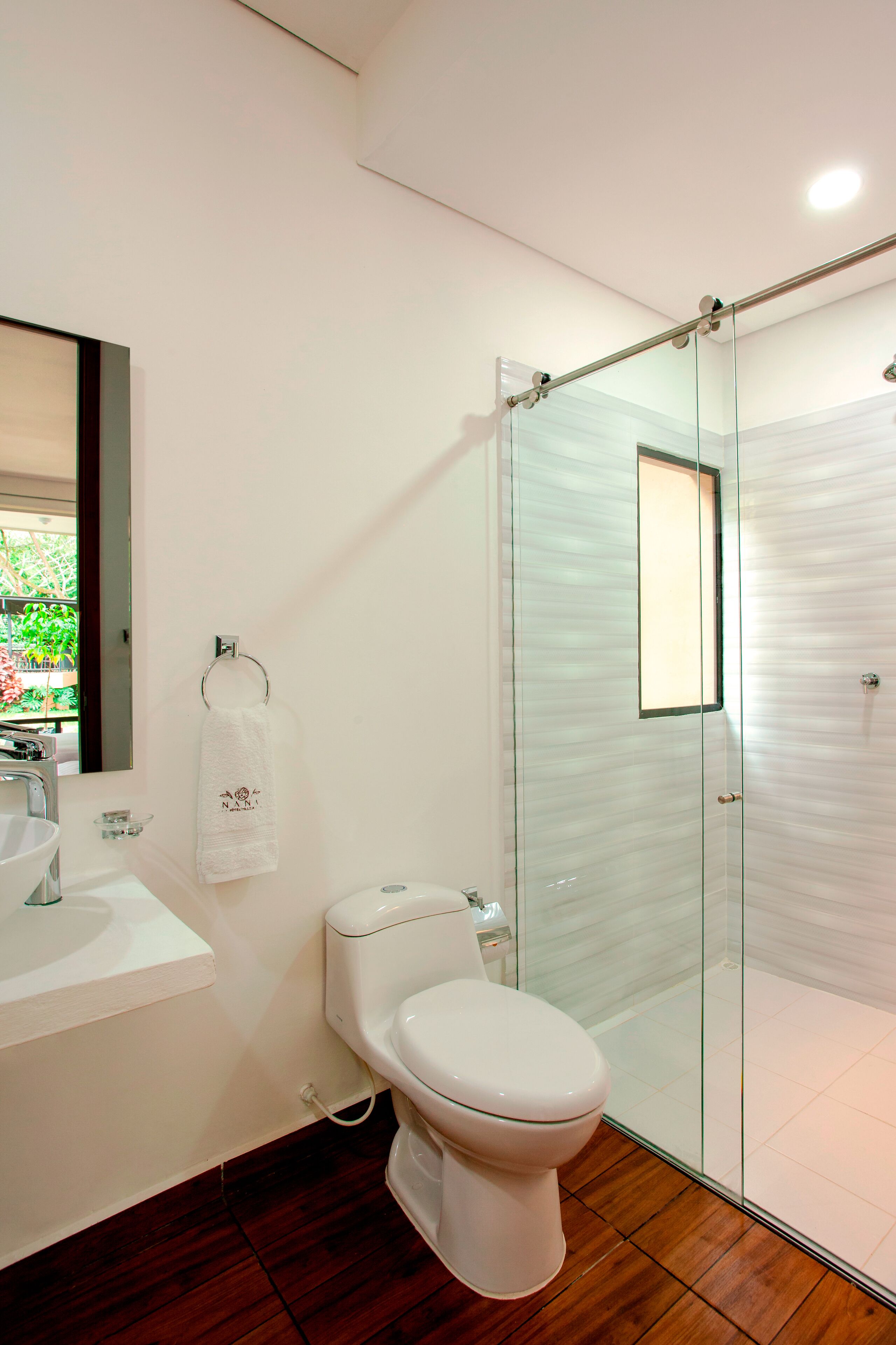 Une salle de bain moderne avec une douche à parois de verre, des toilettes blanches et un lavabo.