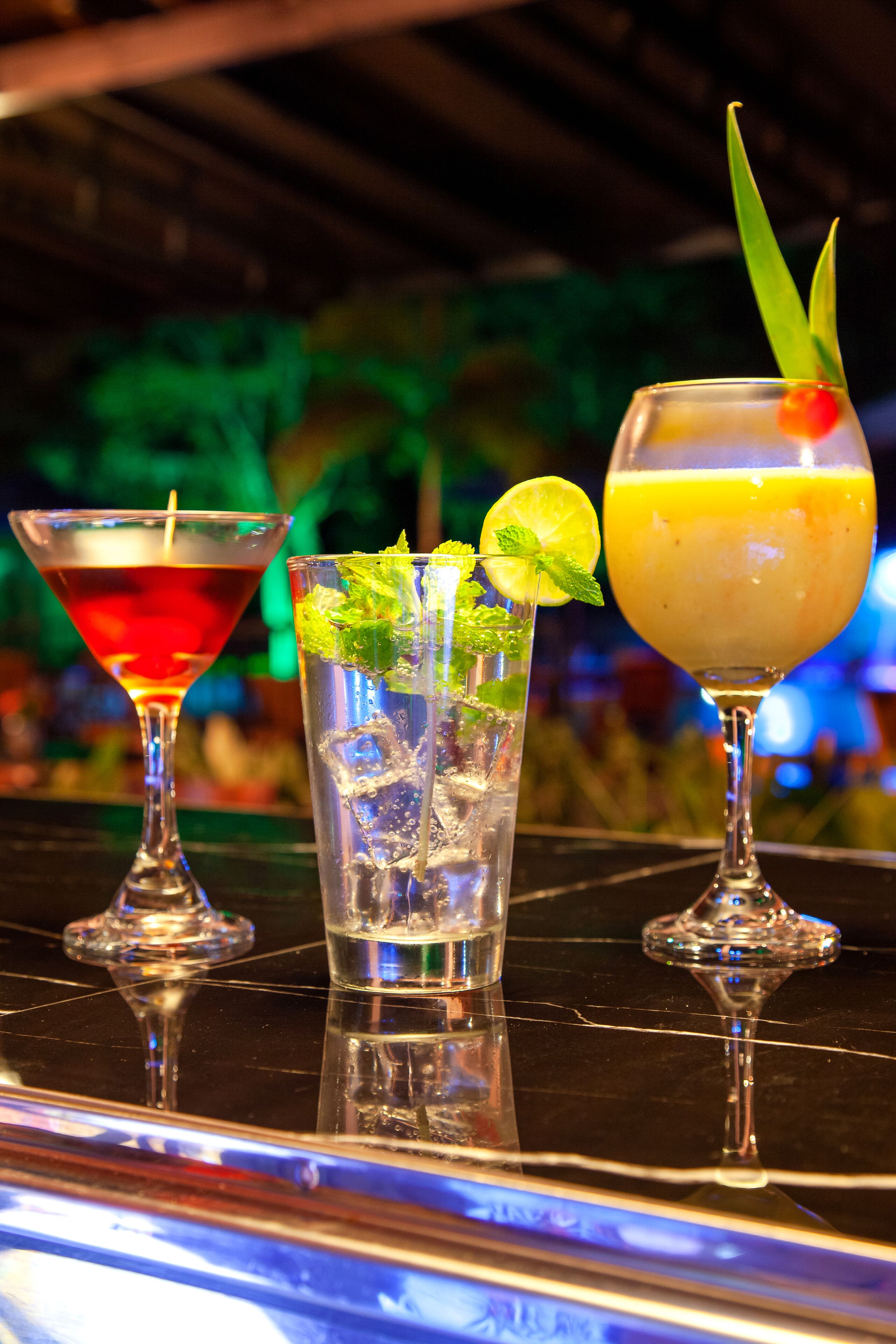 Three cocktails on a bar counter.