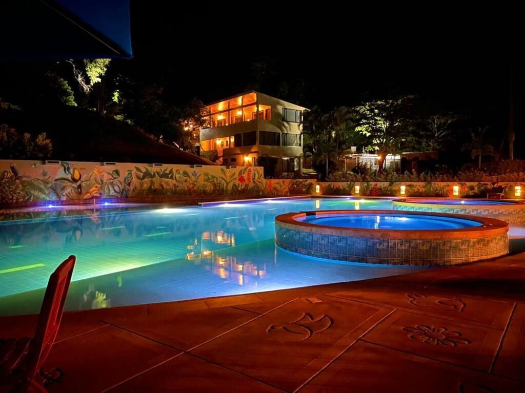 A swimming pool with a circular hot tub, surrounded by a tiled deck with an 'Om' symbol.