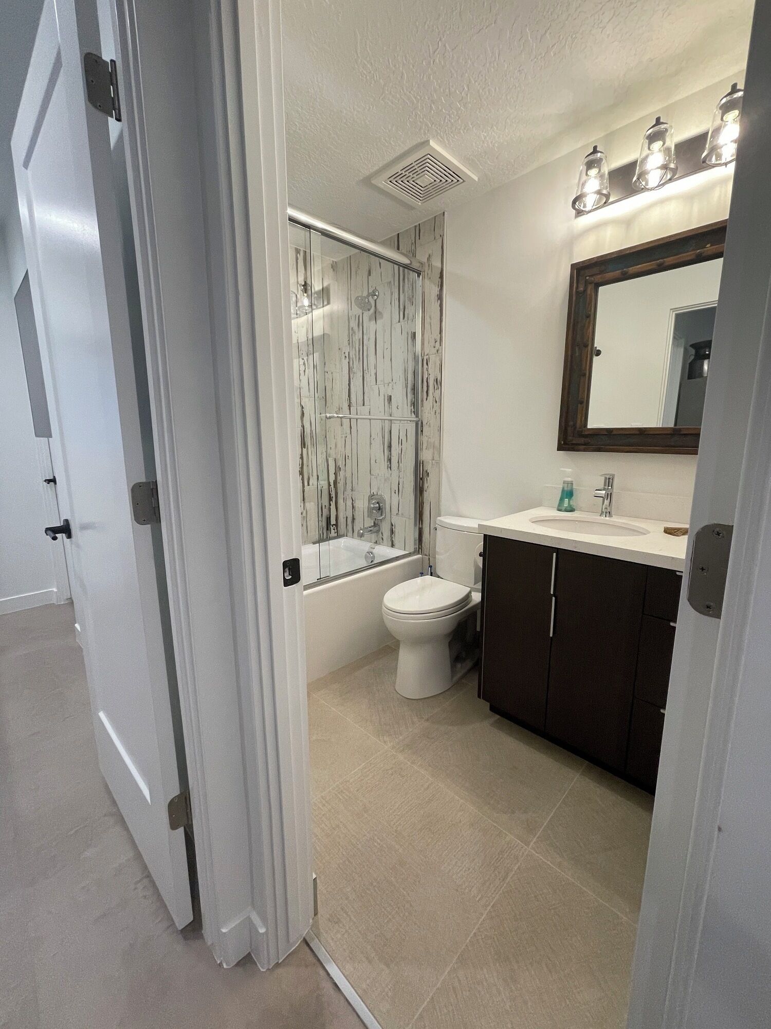 A modern bathroom with a bathtub, toilet, and vanity.
