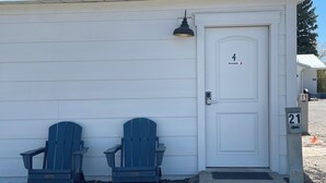 A small, single-story building with a white exterior and a door marked with the number 4. - Modern, One Bedroom Pet Friendly Apartment in Bryce Canyon Country, Panguitch, Utah (Panguitch)
