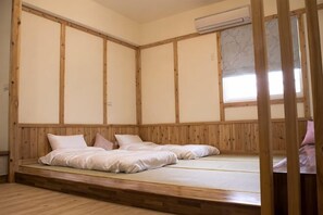 Une pièce avec un lit bas en bois, une fenêtre donnant sur un beau paysage et un lambris en bois.