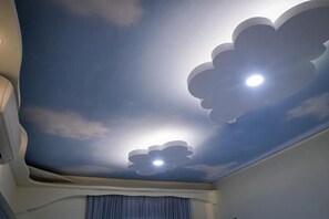 Ein Zimmer mit einer Himmel-Decke, bemalt mit Wolken und Sonne.