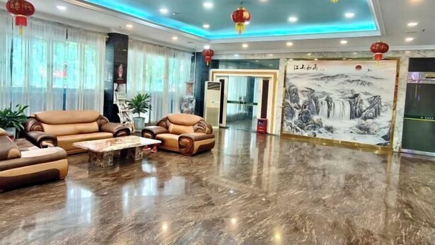 Un hall d’entrée spacieux, doté de canapés en cuir, d’un sol en marbre poli et d’œuvres d’art chinoises traditionnelles.