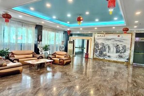 A spacious lobby with leather sofas, a marble floor, and a traditional Chinese painting. - Ronglian Hotel (Foshan)