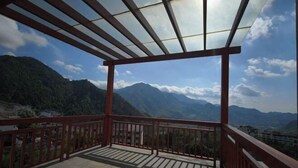 Un balcón con vistas a montañas y un cielo despejado.