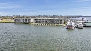 Un hôtel situé au bord de l’eau, avec un long bâtiment, un quai et un bateau.