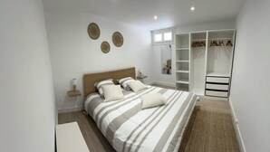 A bedroom with a bed, bedside tables, a wardrobe, and a mirror.