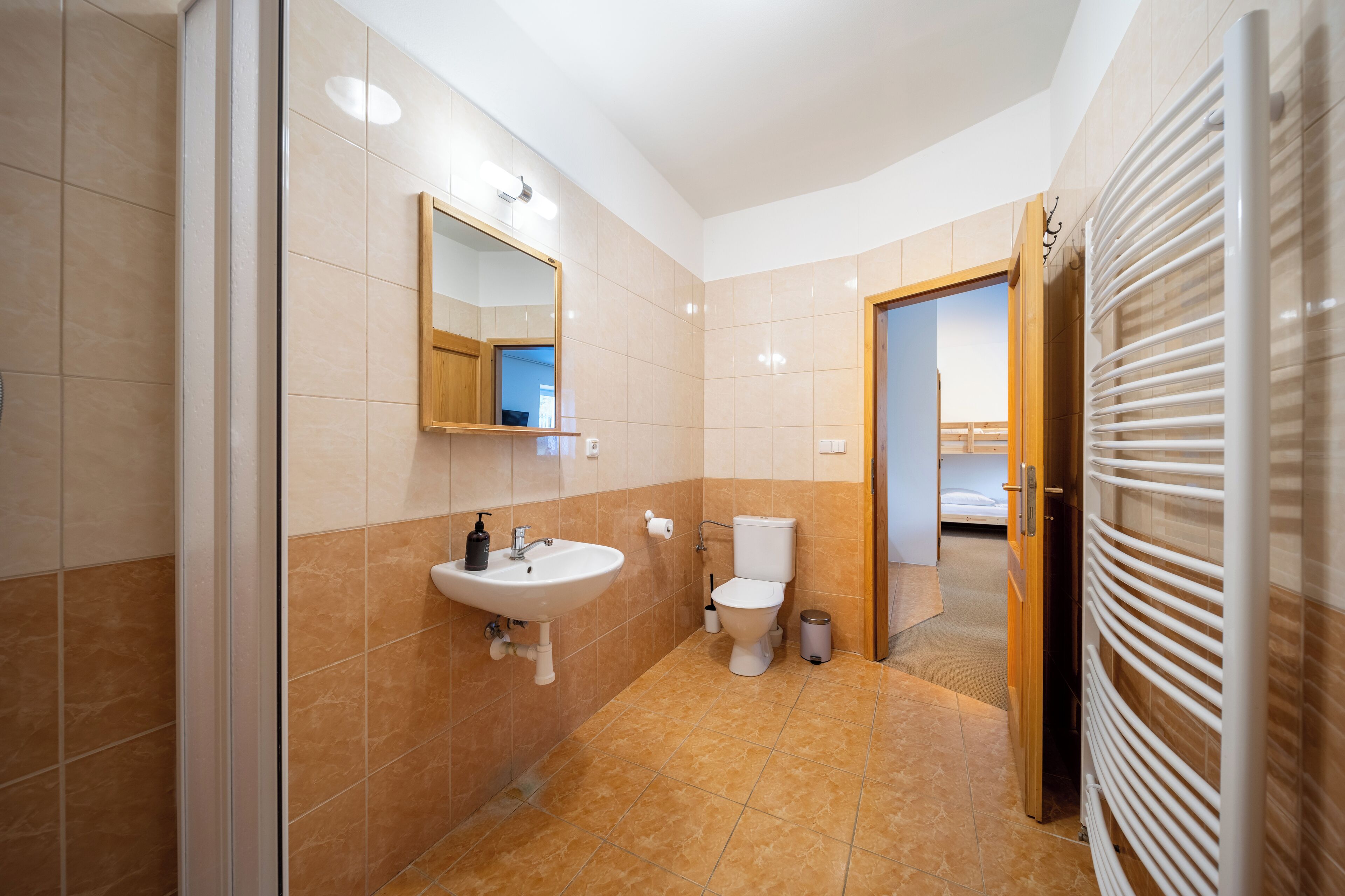 Et moderne badeværelse med vask, toilet og bruser.