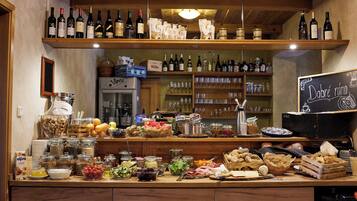 Un buffet ricco di cibi, bevande e una selezione di vini.