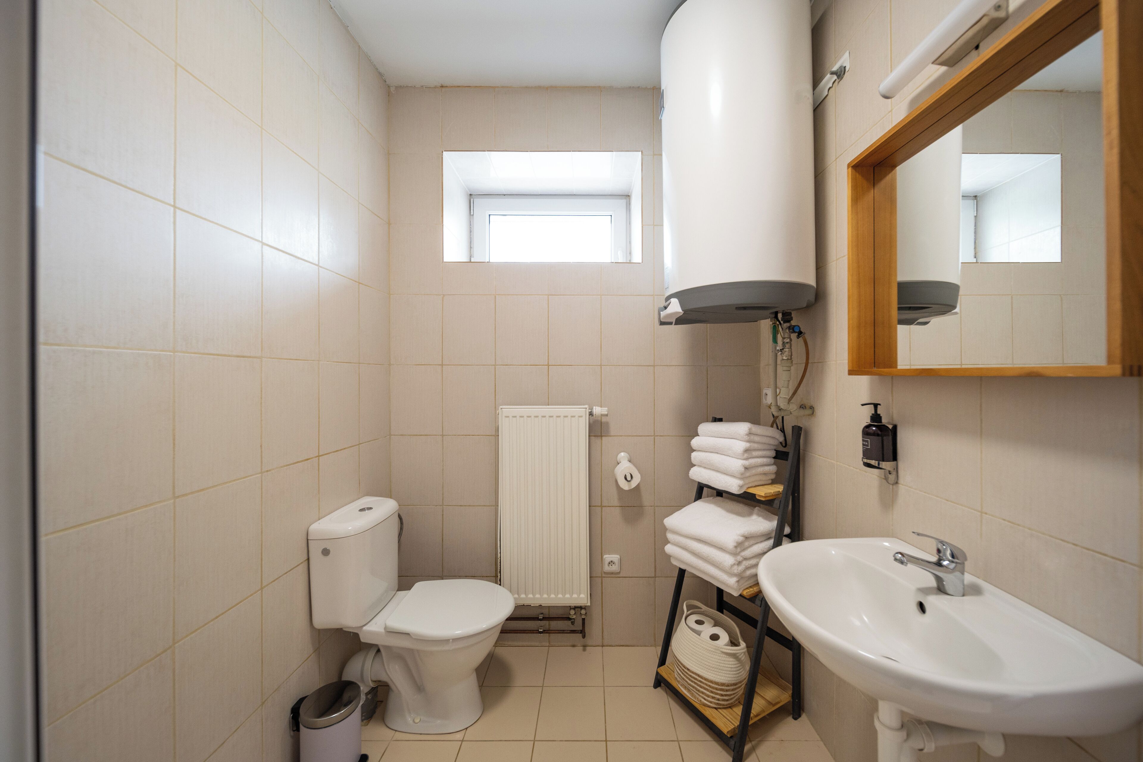 A small bathroom with a toilet, sink, and a window.