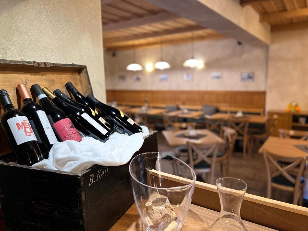A wooden crate with wine bottles and glasses on a table in a restaurant.