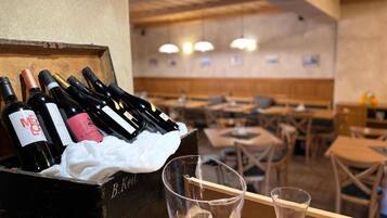 A wooden crate with wine bottles and glasses on a table in a restaurant.