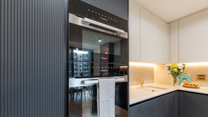 A modern kitchen with a built-in oven, a stainless steel range hood, and a white countertop. - Farringdon Lux 2-bed flat w. Balcony - Clerkenwell (London)