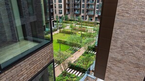 A high-rise building with a view of a well-maintained courtyard featuring pathways, greenery, and a small pond. - Farringdon Lux 2-bed flat w. Balcony - Clerkenwell (London)