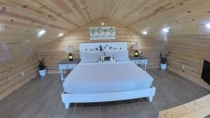 A cozy wooden cabin bedroom with a bed, nightstands, and potted plants. - Million Dollar View Home by New River Gorge Park (Cool Ridge)