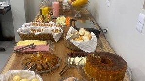 A buffet table with various food items including bread, pastries, and desserts. - HOTEL RIO JORDÃO (Sideropolis)