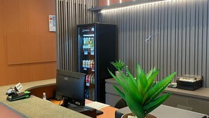 A reception area with a counter, a vending machine, a computer, and a potted plant. - HOTEL RIO JORDÃO (Sideropolis)