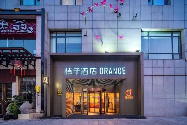 The exterior of a hotel named 'Ciku Hotel Orange' with a modern facade, a revolving door entrance, and a visible sign with the hotel's name. - Orange Hotel (Chengdu Global Center) (Chengdu)
