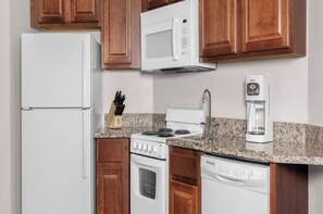 Cafetera o tetera, frigorífico, microondas y mesa de comedor