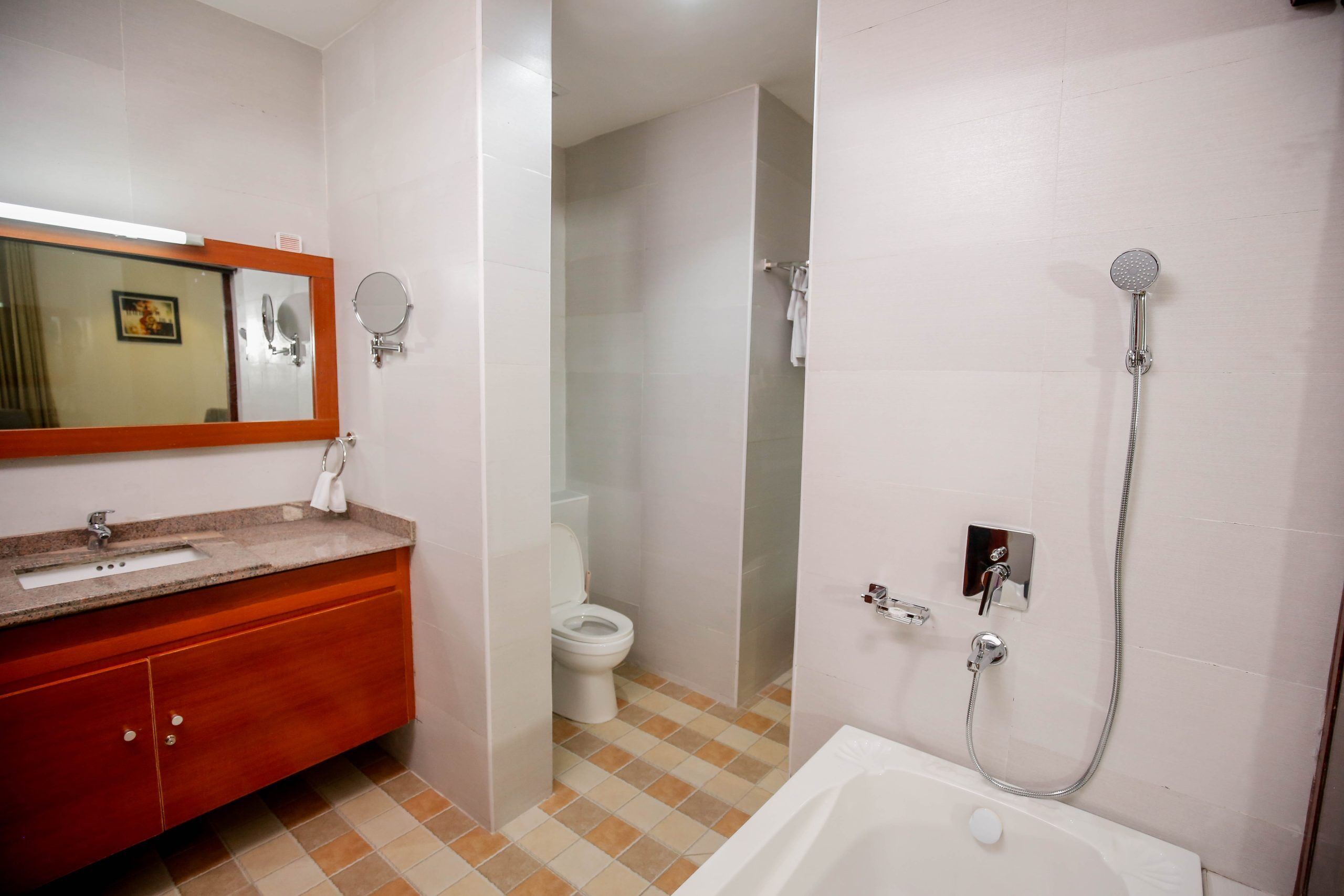 A bathroom with a sink, mirror, toilet, and shower.
